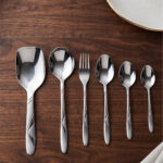 6.jpg displays an elegant 37-piece stainless steel cutlery set, featuring an assortment of tablespoons, teaspoons, forks, knives, and serving utensils arranged neatly on a wooden background to showcase the sophisticated design and finish.