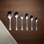 A high-quality 53-piece stainless steel cutlery set arranged elegantly on a dark wood background featuring various spoons, forks, and knives as displayed in 6.jpg.