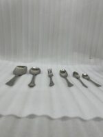 A complete 53-piece stainless steel dining cutlery set featuring spoons, forks, knives, and a serving stand displayed elegantly on a wooden background, as featured in 8.jpg.