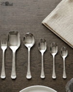 An elegant assortment of stainless steel flatware, including various spoons, forks, and knives arranged on a wooden table as featured in 6.jpg, representing a complete 53-piece dining set.