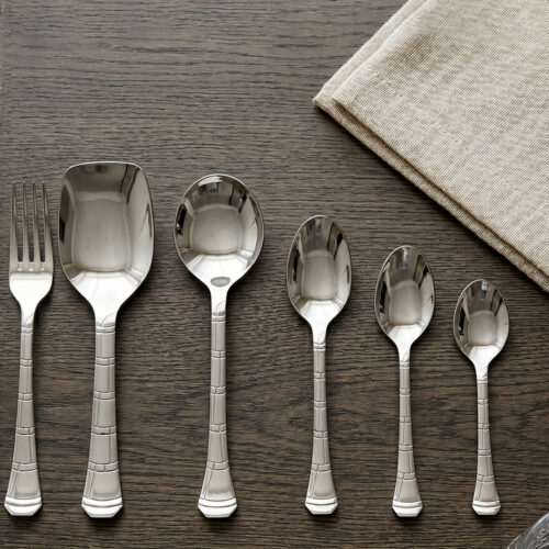 An elegant assortment of stainless steel flatware, including various spoons, forks, and knives arranged on a wooden table as featured in 6.jpg, representing a complete 53-piece dining set.