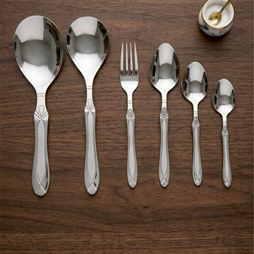 High-quality stainless steel cutlery set featuring table spoons, tea spoons, forks, and serving utensils arranged on a dark wooden background, as displayed in 7.jpg.