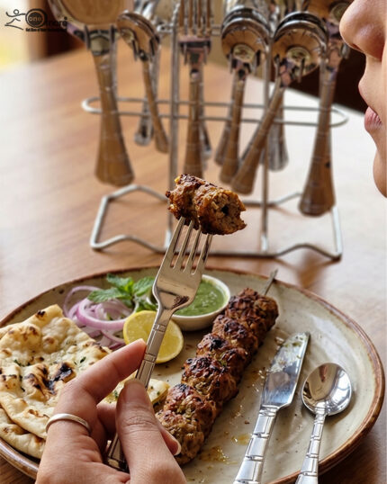 The image 6.jpg displays a selection of items from a 37-piece stainless steel cutlery set, neatly arranged on a wooden background, showcasing the sleek design and finish of the spoons, forks, and serving utensils.