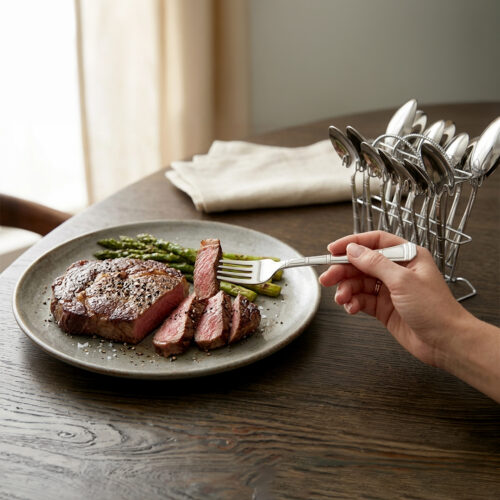 An elegant assortment of stainless steel flatware, including various spoons, forks, and knives arranged on a wooden table as featured in 6.jpg, representing a complete 53-piece dining set.