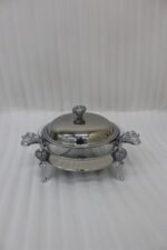 Premium 2-liter glass chafing dish with an ornate silver stand, dome lid, and integrated buffet burner holder on a wooden dining table, branded by One More.