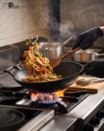 A 30cm granite-coated non-stick open wok being cleaned on a countertop, showcasing its durable surface.