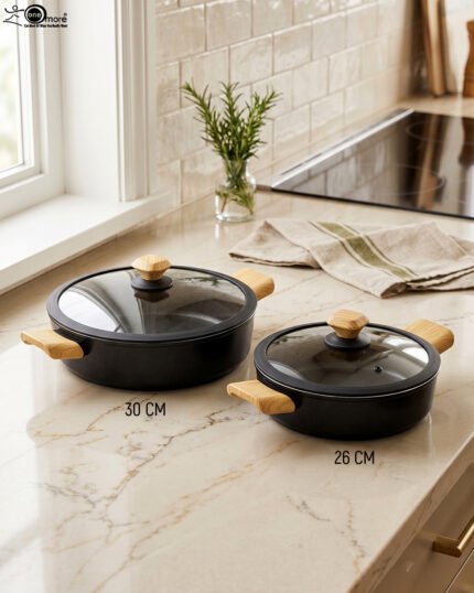 Two black, Made-in-Turkey granite non-stick casserole pots (26cm and 30cm) with wooden-look handles and rubber-rimmed lids sitting on a marble kitchen countertop.