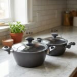 A pair of premium diamond-infused non-stick cooking pots in 20cm and 22cm sizes, made in Turkey, displayed on a marble kitchen countertop.