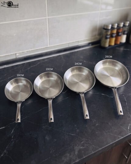 A set of four Made-in-Turkey stainless steel non-stick fry pans in sizes 20cm, 22cm, 24cm, and 26cm arranged on a kitchen counter.