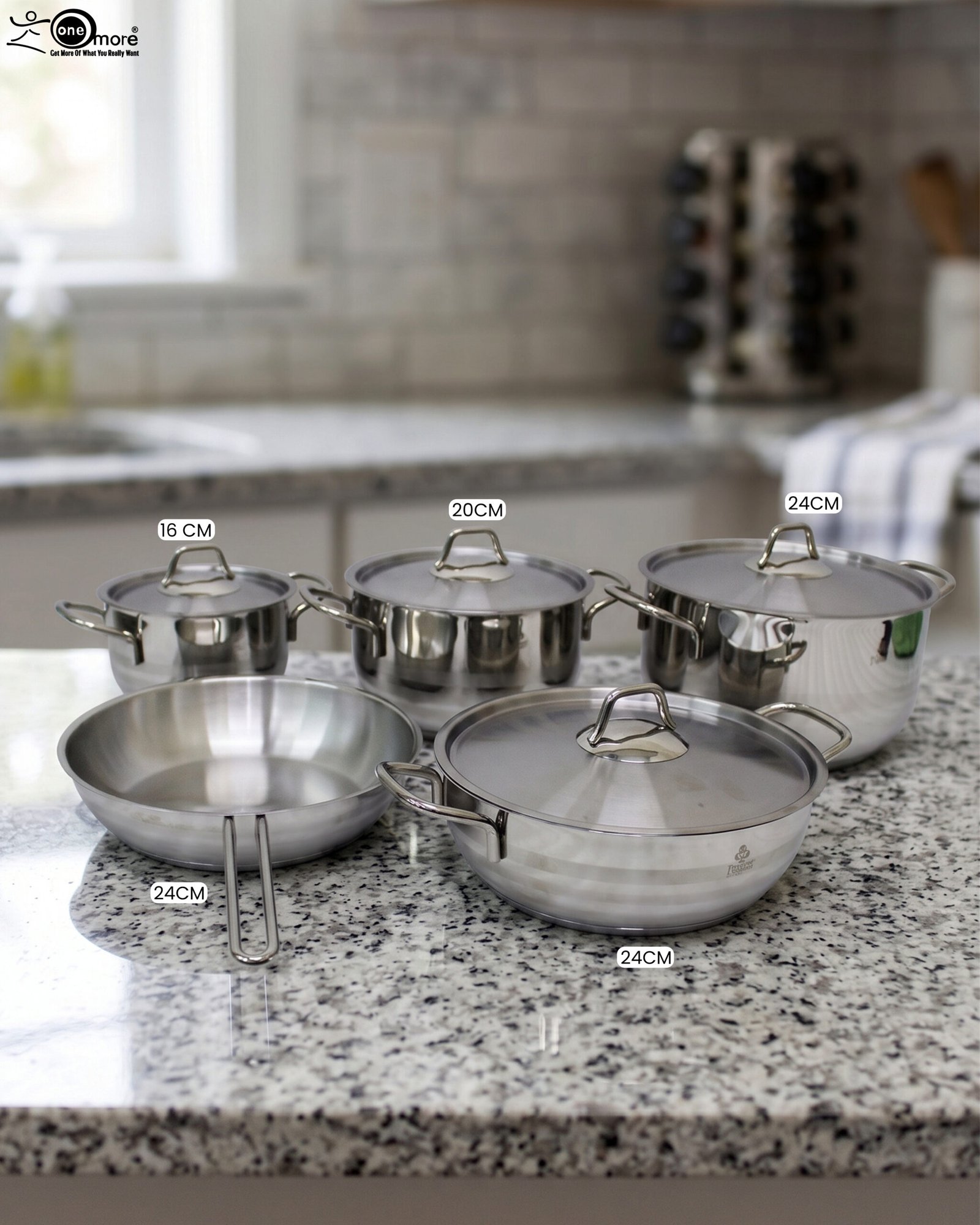 1 Five pieces of stainless steel cookware, including pots and a frying pan with glass lids, arranged on a granite countertop. Sizes 16cm, 20cm, and three 24cm pieces are clearly visible with price tags attached. Product features a non-stick interior and is exclusively available in Pakistan at OneMore.
