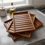 A high-quality 3-piece wooden tray set stacked on a modern kitchen countertop, featuring a natural wood grain finish and durable design, available at OneMore.