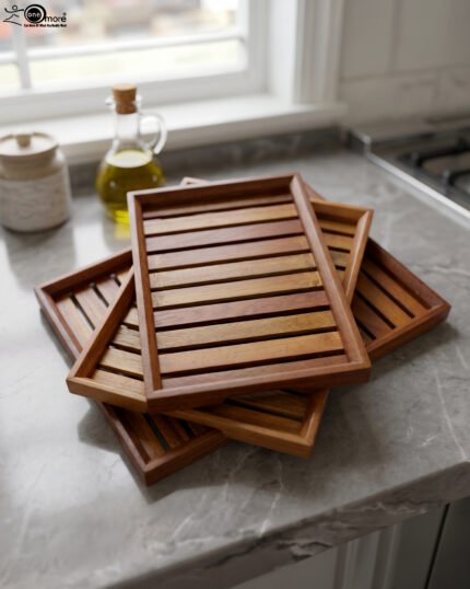 A high-quality 3-piece wooden tray set stacked on a modern kitchen countertop, featuring a natural wood grain finish and durable design, available at OneMore.