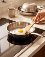 A set of four Made-in-Turkey stainless steel non-stick fry pans in sizes 20cm, 22cm, 24cm, and 26cm arranged on a kitchen counter.