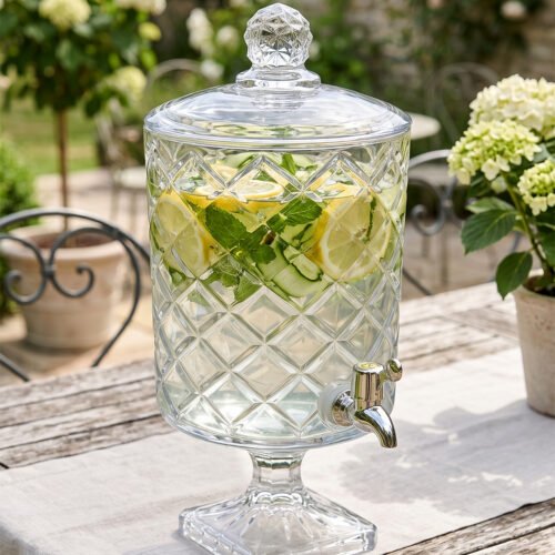 Elegant 4.5-liter diamond-cut glass beverage dispenser filled with infused lemon and cucumber water on an outdoor garden party table, featured in 2.jpg.