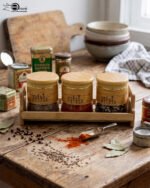 A set of three glass jars with bamboo lids and labels, neatly arranged on a wooden stand in a modern kitchen setting, as seen in 1.jpg.