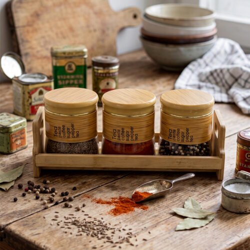 A set of three glass jars with bamboo lids and labels, neatly arranged on a wooden stand in a modern kitchen setting, as seen in 1.jpg.