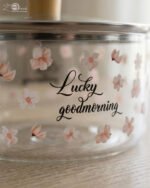 Alt Text: One More 2.5L square glass pot with floral prints, clear glass lid, and a wooden knob resting on a marble countertop.