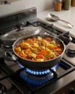 A premium 26cm non-stick granite pot made in Turkey, displayed on a kitchen counter with a matching glass lid and a spatula, available at OneMore.