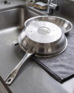 A set of four Made-in-Turkey stainless steel non-stick fry pans in sizes 20cm, 22cm, 24cm, and 26cm arranged on a kitchen counter.