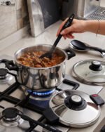 Falez 6L non-stick stainless steel 6-piece cooker set featuring a pot, lid, two spoons, and a heat-resistant table pad on a countertop.
