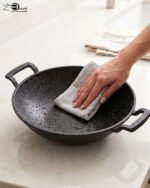 A 30cm granite-coated non-stick open wok being cleaned on a countertop, showcasing its durable surface.