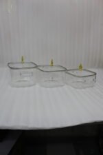 Three premium square glass cooking pots in 3.5L, 4L, and 5L sizes with ornate gold lid knobs on a marble kitchen countertop.