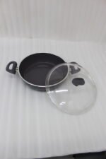 A premium 26cm non-stick granite pot made in Turkey, displayed on a kitchen counter with a matching glass lid and a spatula, available at OneMore.