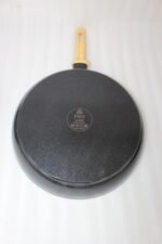 A collection of Turkish-made diamond-infused non-stick frying pans in various sizes ranging from 20cm to 30cm, displayed on a kitchen wall and countertop at OneMore.