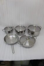 Five pieces of stainless steel cookware, including pots and a frying pan with glass lids, arranged on a granite countertop. Sizes 16cm, 20cm, and three 24cm pieces are clearly visible with price tags attached. Product features a non-stick interior and is exclusively available in Pakistan at OneMore.