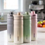 Four pastel gradient Dodge 560mL stainless steel water bottles lined up on a kitchen counter.