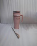 : An array of colorful 1.2L stainless steel tumblers with handles and clear lids displayed on a kitchen counter
