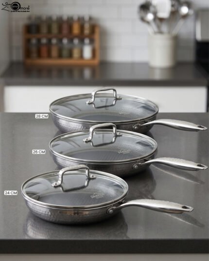 A 3-piece stainless steel cookware set with glass lids featuring 24CM, 26CM, and 28CM sizes displayed neatly on a kitchen counter.
