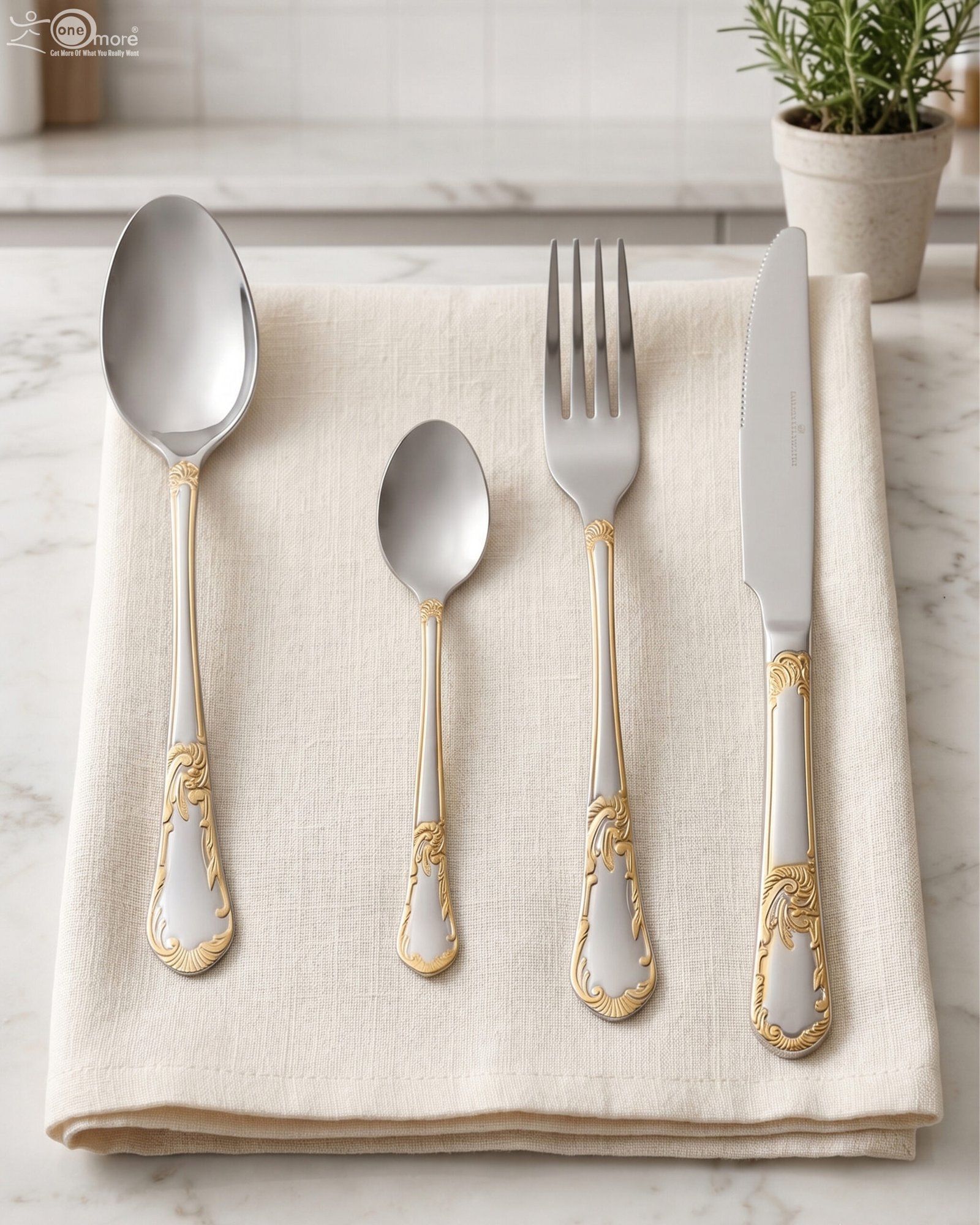 1 24-piece stainless steel cutlery set with ornate gold embossed handles laid out on a beige linen napkin