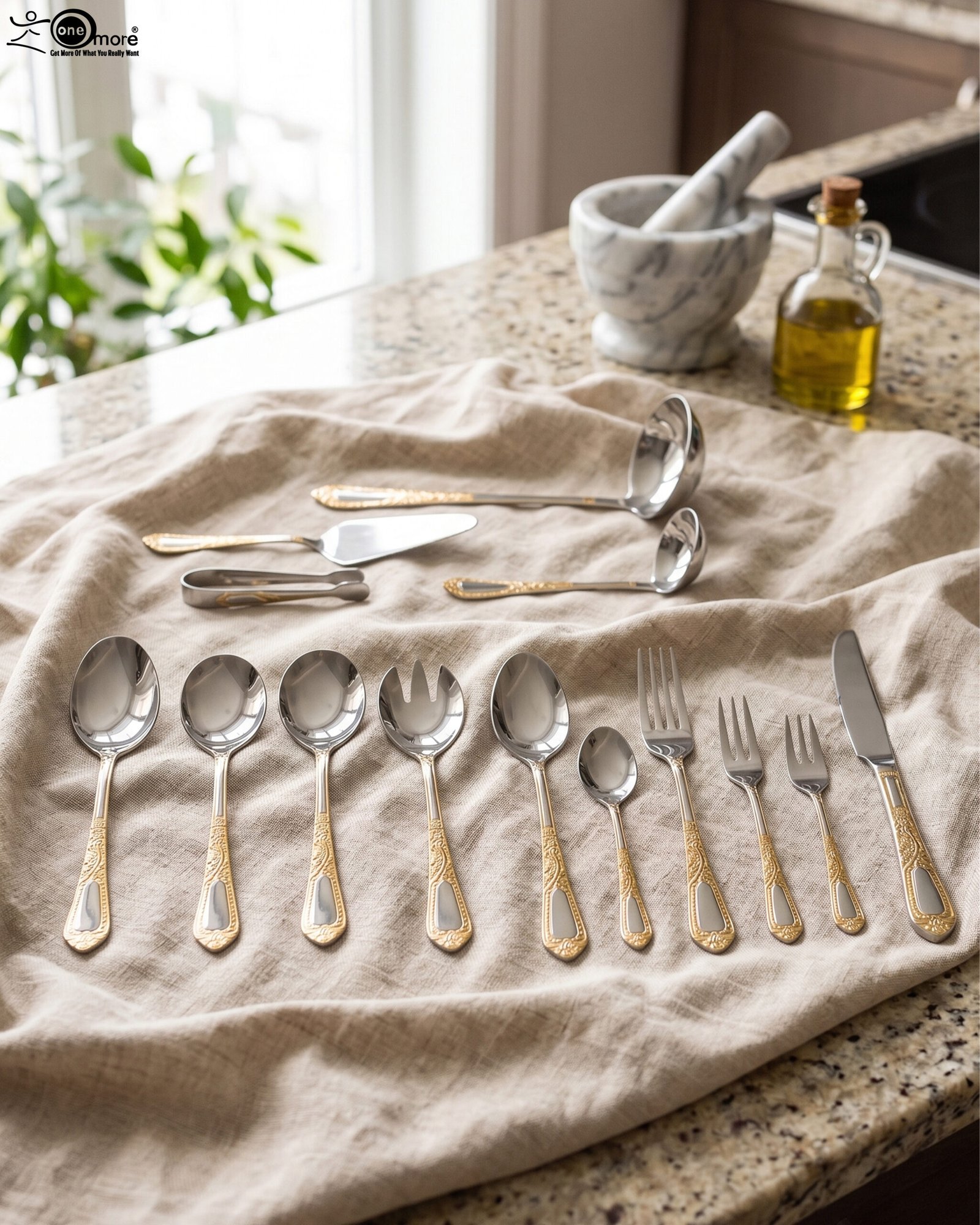 1 72-piece stainless steel cutlery set featuring embossed gold-plated handles laid out on a beige table runner.