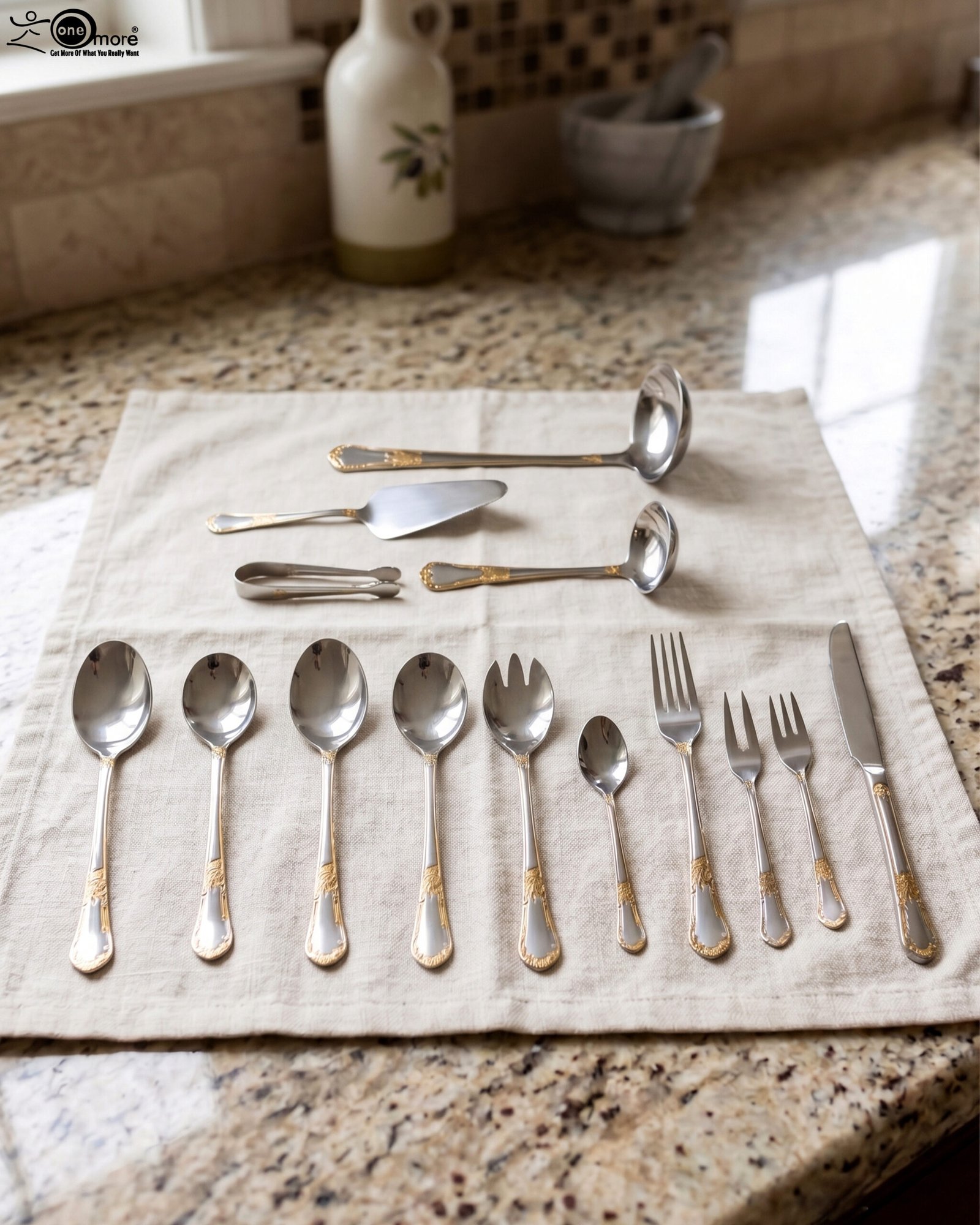 1 72-piece stainless steel cutlery set with gold-embossed handles arranged on a neutral linen cloth