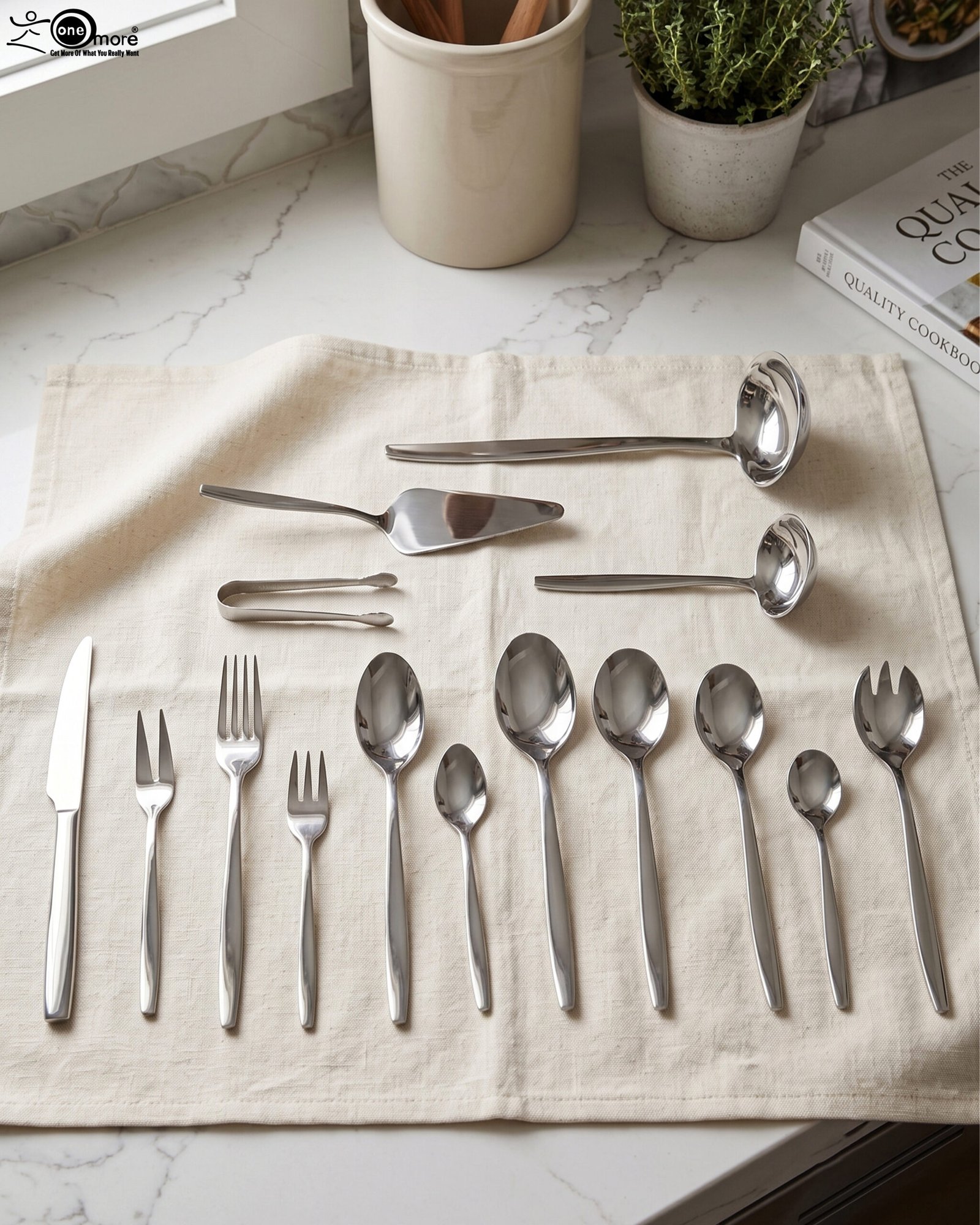 1 72-piece polished stainless steel cutlery set arranged on a cloth napkin featuring place settings, ladles, cake server, and tongs.