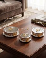 3-piece luxury silver decorative serving dishes with gold floral accents and metallic handles displayed on a wooden coffee table.