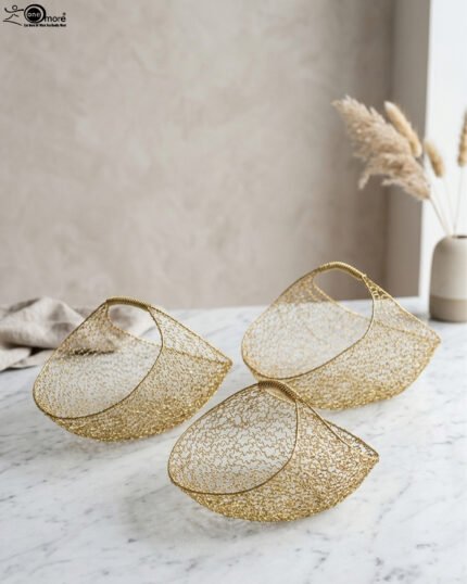 Set of three gold mesh wire decorative metal baskets displayed on a marble countertop with minimalist décor