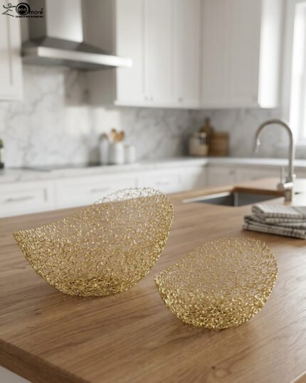 Set of two gold wire decorative metal baskets sitting on a wooden kitchen island counter
