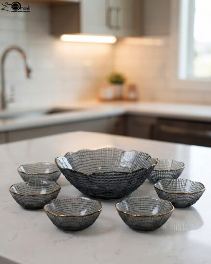 7-piece grey glass fruit set featuring one large serving bowl and six matching small bowls with gold rims, displayed on a kitchen countertop.