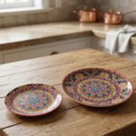 Two decorative Marrakech ceramic plates with vibrant colorful mosaic mandala patterns resting on a rustic wooden table.