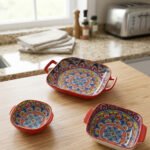 Three vibrant red Moroccan Marrakech decorative ceramic bowls with handles set on a wooden countertop