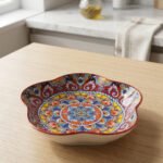 Colorful star-shaped ceramic Marrakesh decorative plate with intricate Moroccan mosaic pattern on a wooden table.