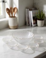 7-piece grey glass fruit set featuring one large serving bowl and six matching small bowls with gold rims, displayed on a kitchen countertop.