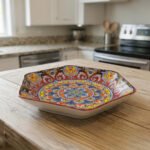 Hexagonal decorative Marakesh plate with vibrant hand-painted Moroccan tile mosaic pattern on a wooden kitchen table.