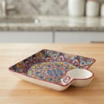 Square ceramic Marrakech serving platter with intricate colorful mosaic patterns and an attached side dip bowl on a wooden countertop.