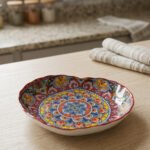 Decorative Marrakesh serving plate featuring vibrant hand-painted mosaic mandala patterns on a wooden countertop.