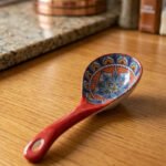 Hand-painted ceramic spoon rest with colorful Moroccan pattern resting on a wooden countertop.
