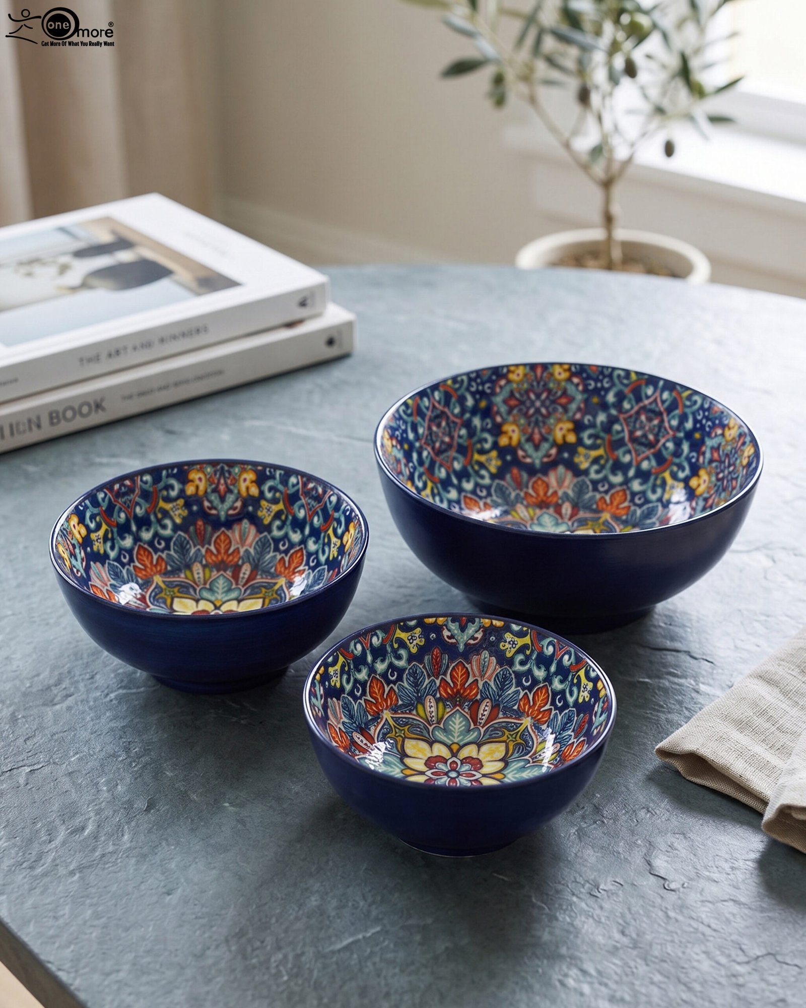 1 Set of three hand-painted decorative Marrakech ceramic bowls with colorful bohemian patterns and navy blue exteriors on a slate table.