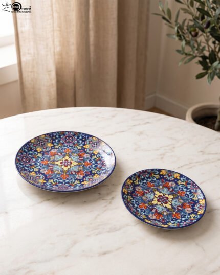Two vibrant blue, yellow, and red decorative Marrakech ceramic plates displaying intricate mosaic patterns on a white marble surface in 8-inch and 10-inch sizes.